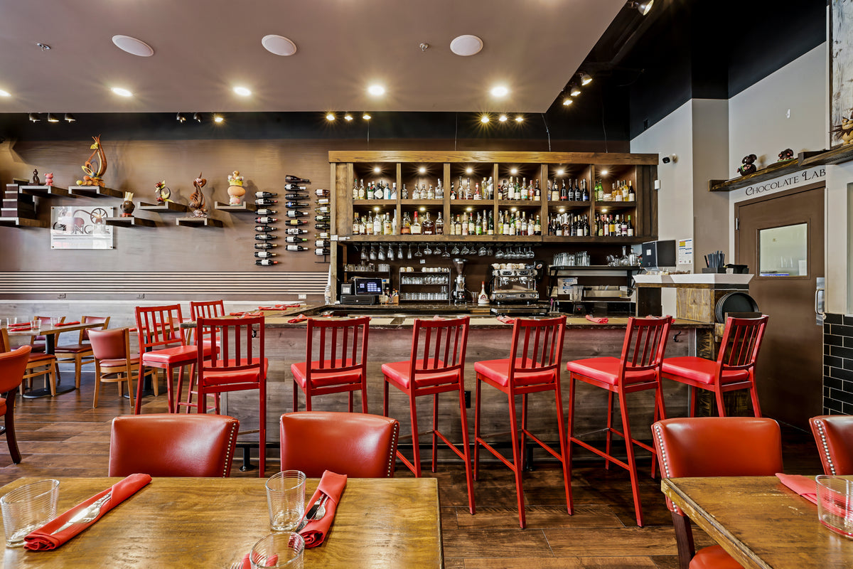 The dining room and bar at The Conche, with red leather chairs and chocolate sculptures on the shelves